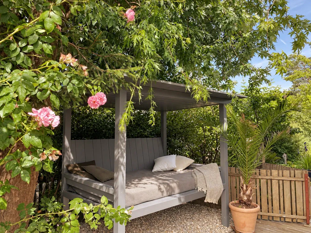 Überdachtes Garten-Liegebett mit Blüten