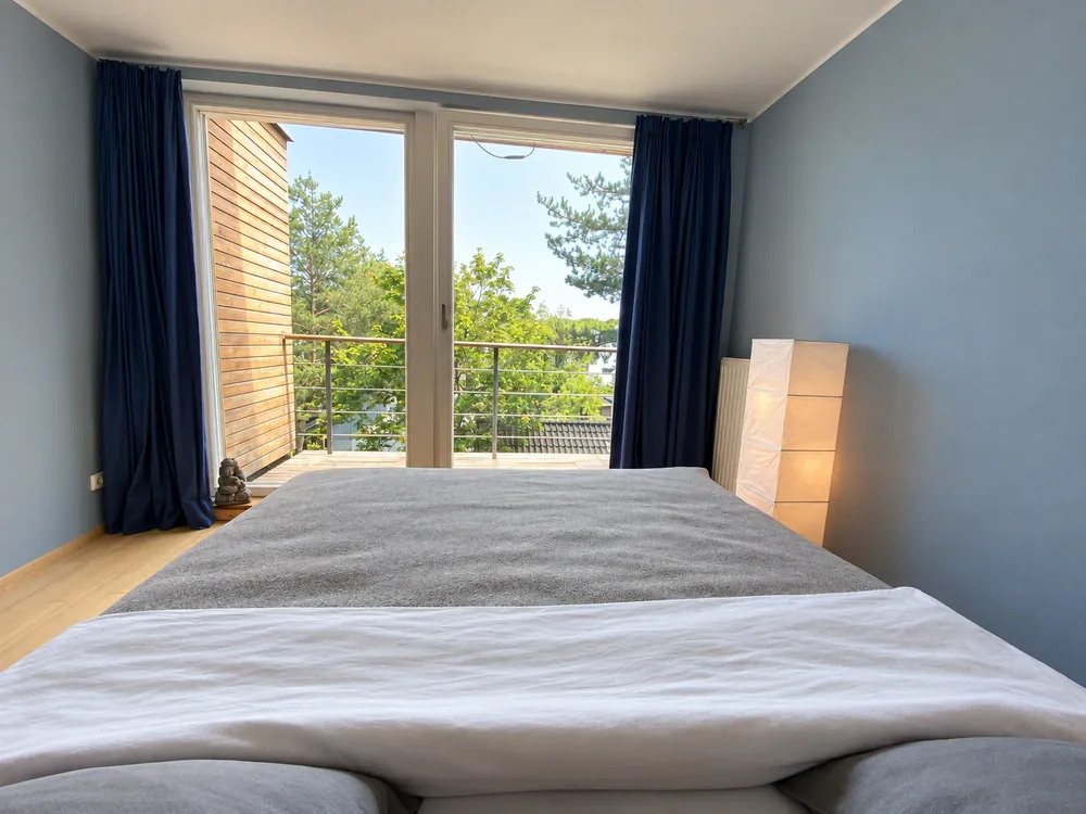 Schlafzimmer mit Blick über das Bett zum Balkon