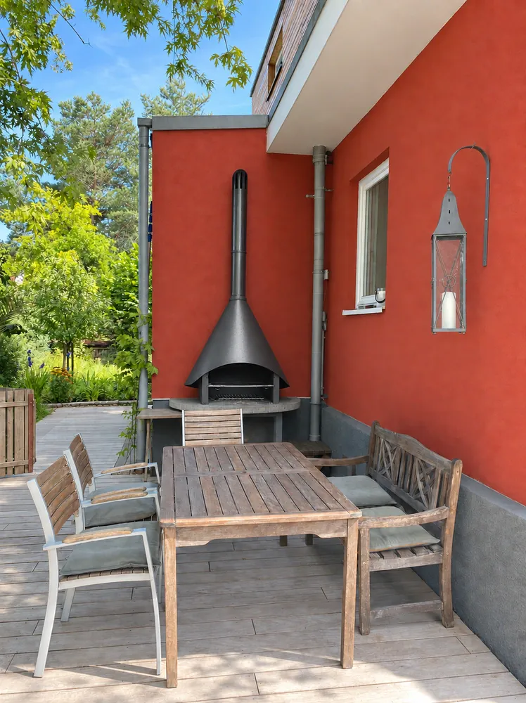 Terrasse mit Holztisch und Außenkamin